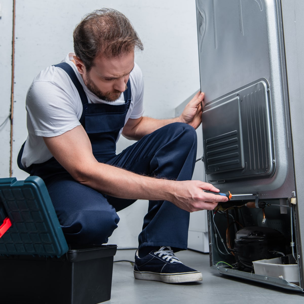 Foto de Técnico revisando estado de nevera Foto de Técnico revisando estado de Frigorífico Bru